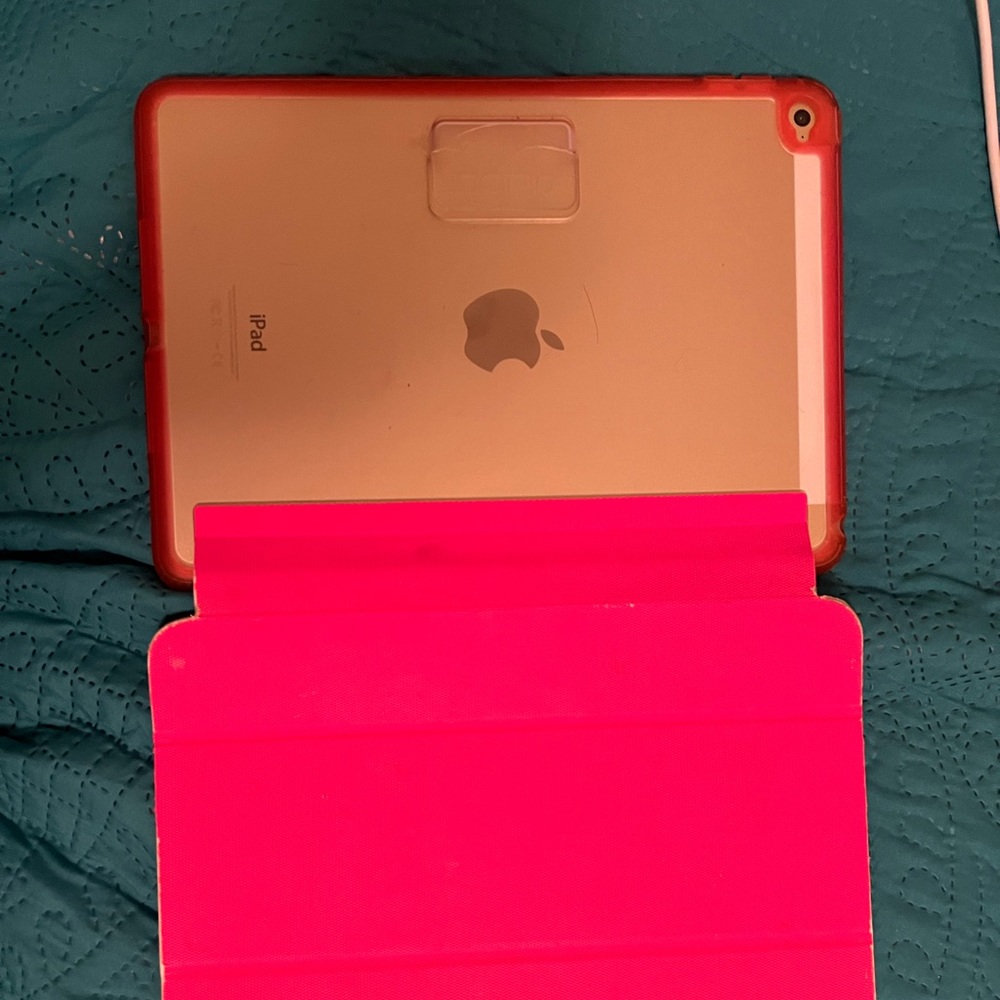 Rose-Gold-colored iPad in good condition. It comes with a case that is worn.